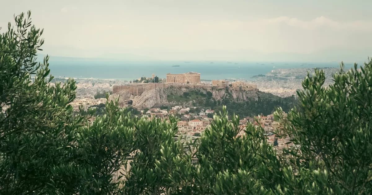 The Acropolis above the rooftops of Athens, Greece, with the sea behind it