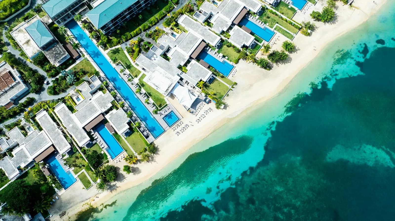 Clifftop villas with private pools above a turquoise Caribbean bay