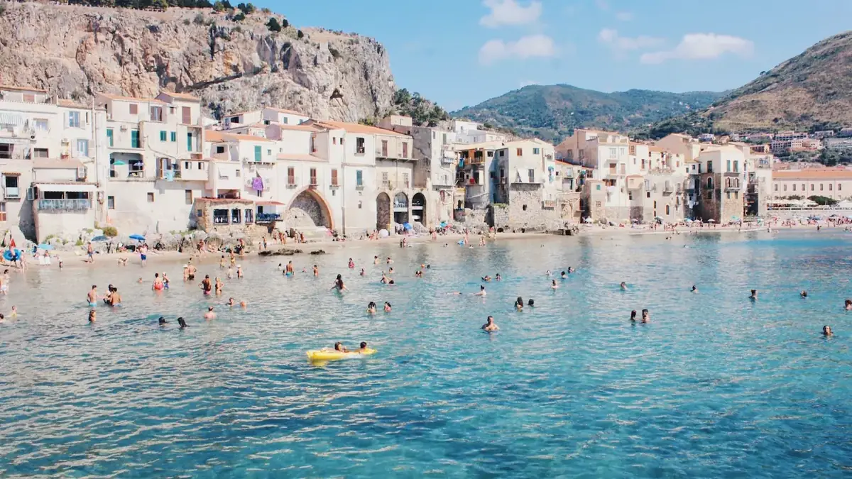 Cefalù beach and old town beneath the cliffs in Sicily, a southern Italian town small enough for Italy's 7% flat tax for foreign retirees
